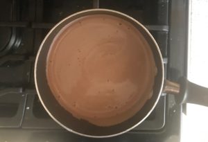 Hot chocolate warming in a pot on stove